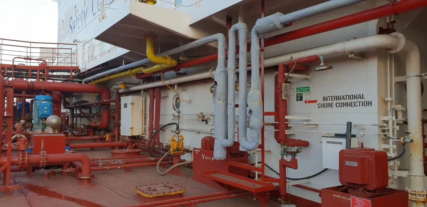Red-painted pipelines and manifolds on a tanker deck