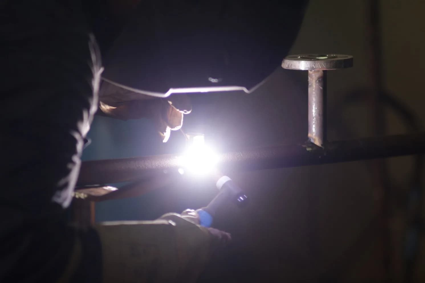 Welder welding a pipe on board